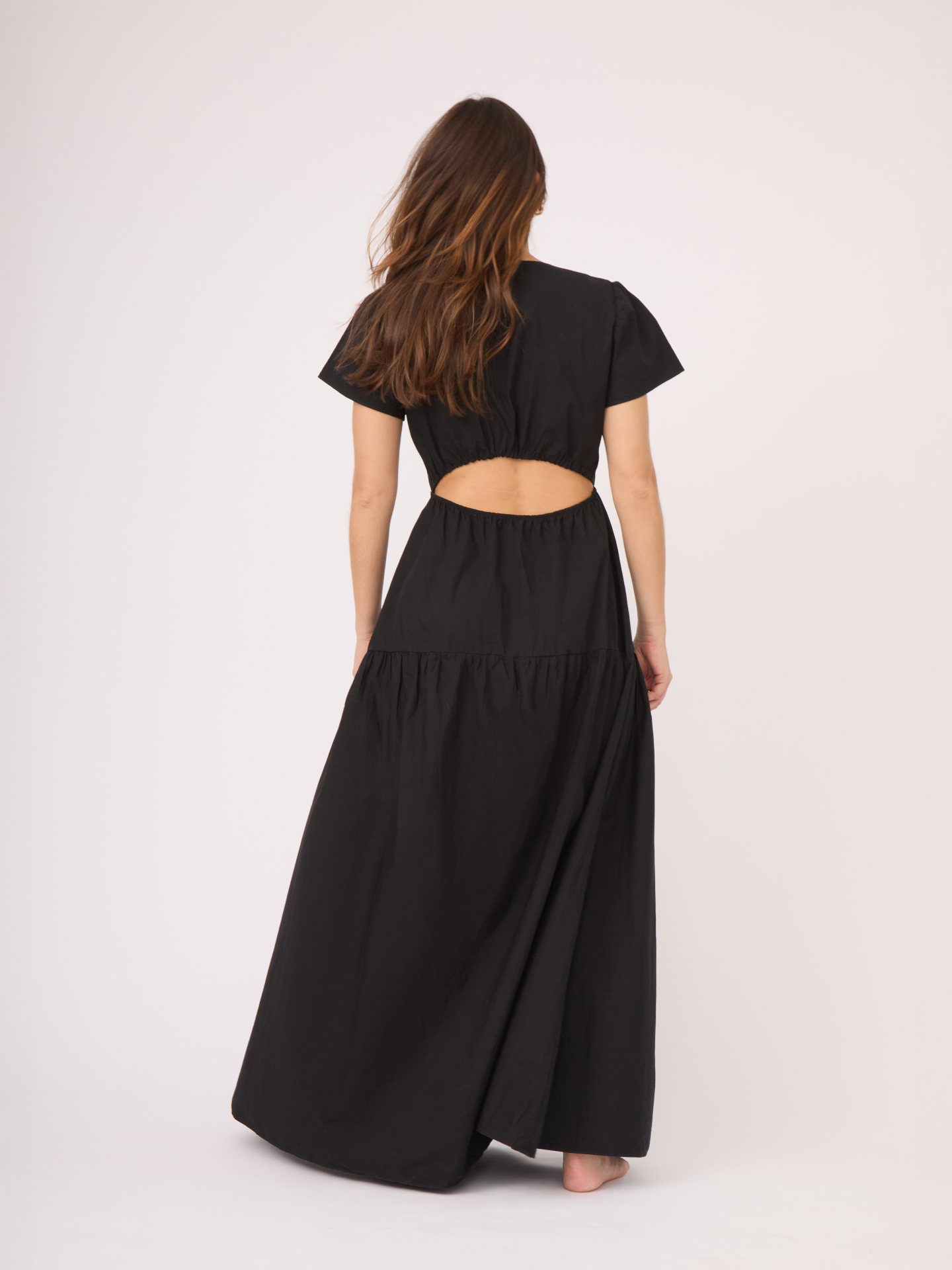 El vestido negro tiene una apertura disimulada en la espalda dandole un toque sensual pero sutil.