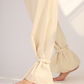 Pantalón marfíl con un sistema para atar a los tobillos que crea una silueta tipo globo. Es versátil ya que se puede usar con bota ancha o cogida.